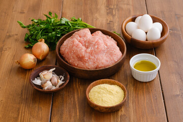 Overhead view of minced meat and ingredients for meatballs on a table