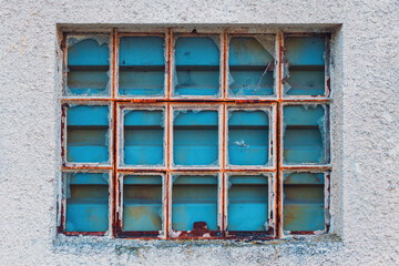Old factory warehouse grid windows with broken glass