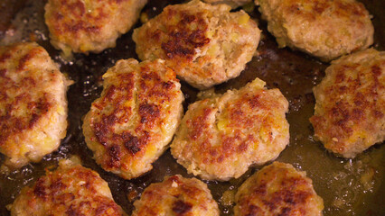 Process of cooking meat cutlets in oil in frying pan.