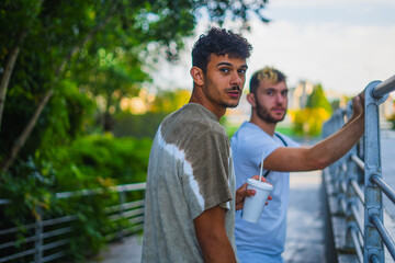 Gay couple on a sunny day. a young gay couple enjoying a walk drinking a fresh coffee