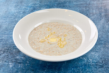 Bowl with tasty oatmeal with butter