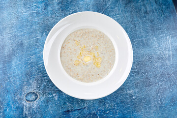 Bowl with tasty oatmeal with butter