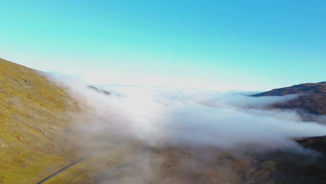 Aerial establishing shot of low-lying clouds within the valley in Iceland