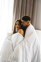 Couple in love posing in blankets in a hotel room in the mountains. Concept for a vacation in the mountains