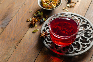 Obraz na płótnie Canvas Herbal Tea, Hibiscus Red Tea in Glass Cup on Wooden Background, Autumn or Winter Drink