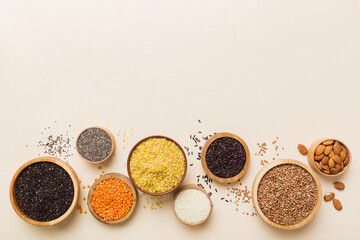 Various superfoods in smal bowl on colored background. Superfood as rice, chia, quinoa, lentils, nuts, sesame seeds, almonds. top view copy space