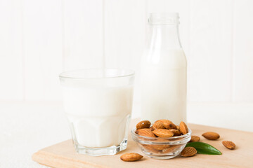 Top view of the almond milk in the glass bottle with almond nuts on the colored table. top view vith copy space