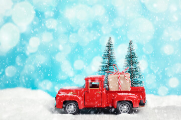 Red toy pickup truck with a gift. Merry Christmas and New Year greetings, boxing day, delivery.