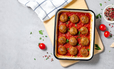 Meatballs in Tomato Sauce, Homemade Meatballs in a Baking Dish on Bright Concrete Background