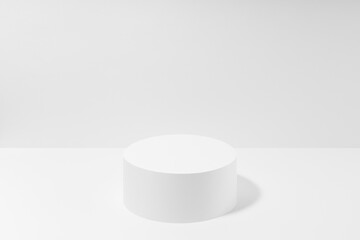Abstract one white round podium for cosmetic products in hard light, mockup on white background. Scene for presentation products, gifts, goods, advertising, design, sale, display, showing.