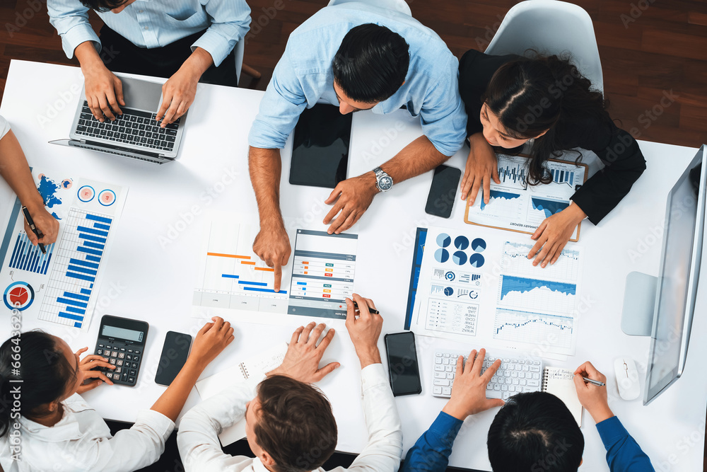 Poster Top view analyst team utilizing BI Fintech to analyze financial data at table in meeting room. Analytic BI dashboard power on paper for business insight and strategic marketing planning. Prudent