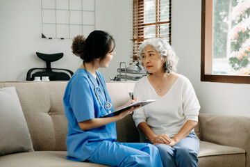 Asian caregiver doctor examine older patient use blood pressure gauge. woman therapist nurse at nursing home taking care of senior elderly woman sit on sofa.Medical service concept..
