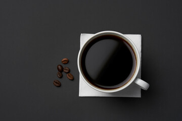 Black coffee and coffee beans on black background