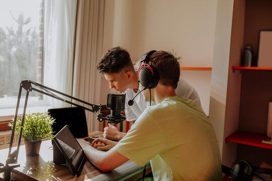 Teenage friends podcasting with laptop and tablet PC at home