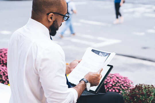 Black focused businessman working with gadget outside