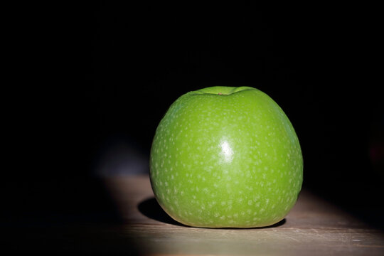 a green apple isolated on dark background