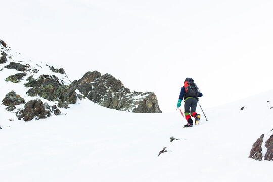 Man walking with pole on mountain in winter