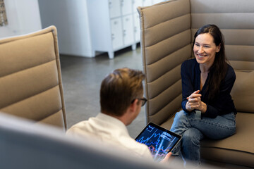 Smiling businesswoman having discussion with colleague in office