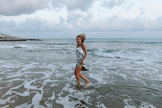 Blond woman wearing dress enjoying at beach
