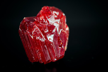 red mineral crystal on a black background