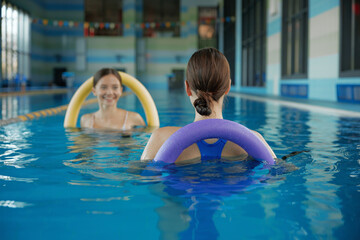 Female fitness class of aqua aerobics at indoors swimming pool