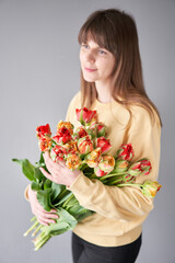 Tulip Gudoshnik in woman hand. Spring bouquet of red tulips in hands. Bunch of fresh cut spring flowers