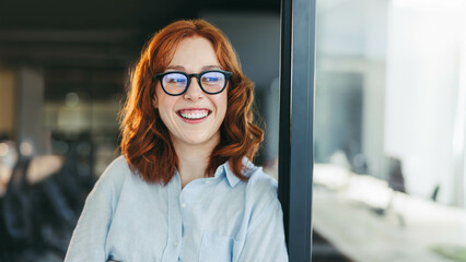 Successful businesswoman in glasses smiling at her workplace