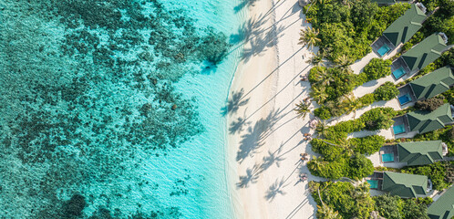 Aerial top view beach. Tropical beach white sand turquoise sea palm trees shadows sunlight. Drone...