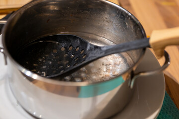 a straining spoon in the kitchen in a cooking pot