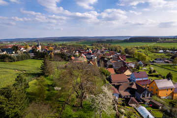 Village surrounded by beautiful hilly green landscape at a colorful sunrise.