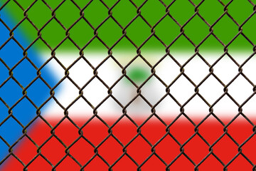Fototapeta premium A steel mesh against the background of the flag Equatorial Guinea.