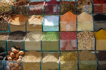 the display of a variety of different spices and nuts in glass containers
