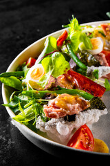 Salad nicoise. Tuna, with green beans, tomatoes, potatoes and a vinaigrette mustard dressing in white plate