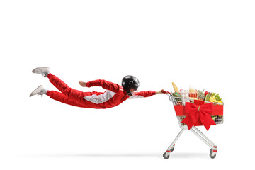 Car racer flying and holding a shopping cart with food and red ribbon bow