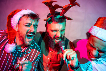 Guys having fun singing karaoke at New Year Eve party