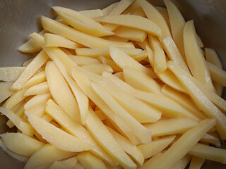 tas de frites fraiches crues, en gros plan, dans un plat