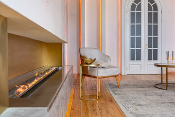 cozy interior of a modern living room with a fireplace, decorative panels and LED lighting with...