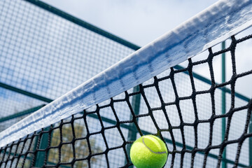 ball hitting the net of a paddle tennis court