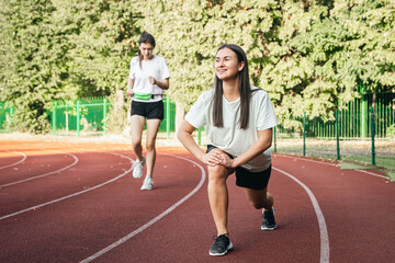 Obraz premium A young woman runner in start position on running track while work out.