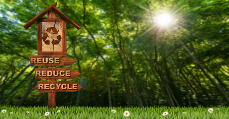 Three wooden directional sign with text Reuse Reduce Recycle and a recycling symbol on a green meadow with green forest on background with sunbeams.