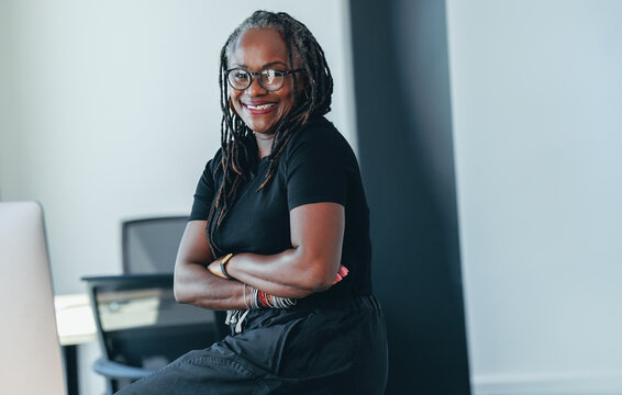 Woman with dreadlocks smiling happily in a professional business office