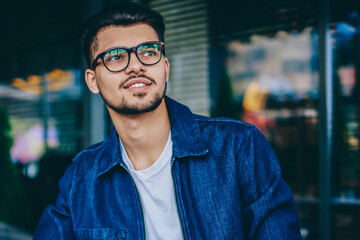 Obraz premium dreaming smiling male student in eyewear looking away making notes