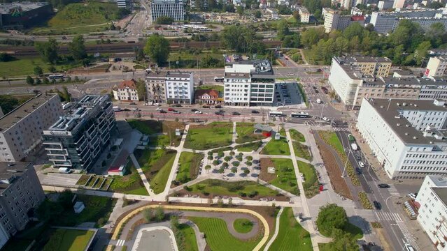 Bird's-eye view of Central Park in Gdynia, highlighting a blend of urban architecture and manicured green spaces, with bustling streets and buildings surrounding.