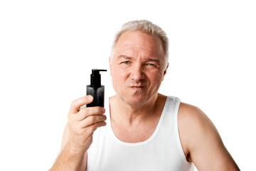 Portrait of middle aged, 45s man made unhappy face holding jar of skin care hand cream, lotion against white studio background.