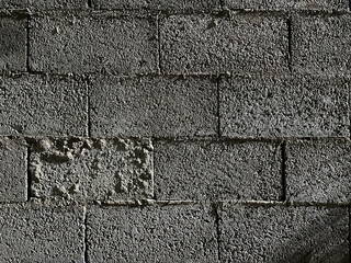 concrete uneven wall of smooth and carved blocks high contrast