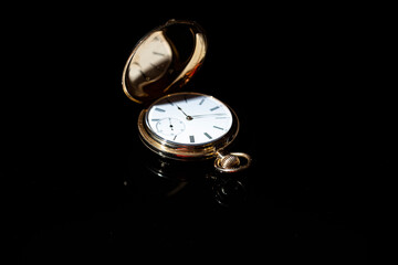 vintage gold pocket watch on black background