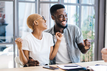 Cheerful African American couple with realtor