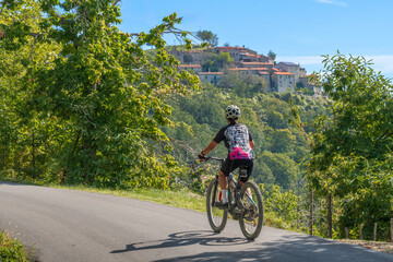 nice senior woman riding her electric mountain bike in the Pratomagno mountains below village of...