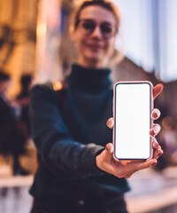  millennial woman showing website on mock up touchscreen of cellphone device