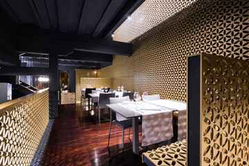 A white table sitting in a room restaurant with gold walls